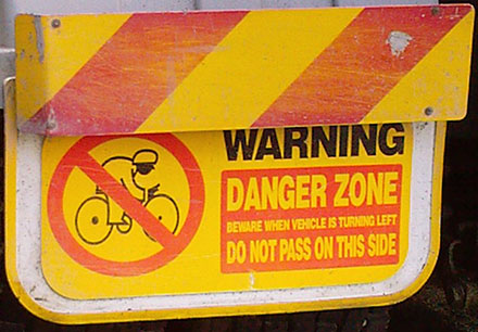 Warning. Danger zone. Beware when this vehicle is turning left. Do not pass on this side.